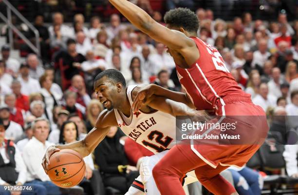 Keenan Evans of the Texas Tech Red Raiders drives around Kameron McGusty of the Oklahoma Sooners during the first half of the game on February 13,...