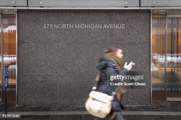 Pedestrian walks past the John Hancock Center, one of Chicago's most famous skyscrapers, on February 13, 2018 in Chicago, Illinois. John Hancock...