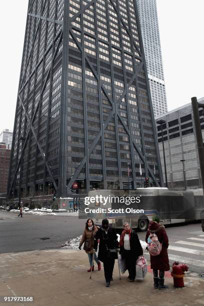 Pedestrians walk near the John Hancock Center, one of Chicago's most famous skyscrapers, on February 13, 2018 in Chicago, Illinois. John Hancock...