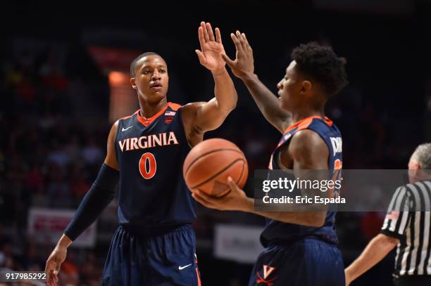 Devon Hall of the Virginia Cavaliers congratulates teammate Nigel Johnson after getting fouled during the first half of the game against the Miami...