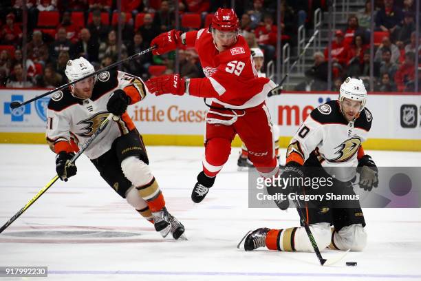 Antoine Vermette of the Anaheim Ducks tries to control the puck in front of Tyler Bertuzzi of the Detroit Red Wings during the third period at Little...