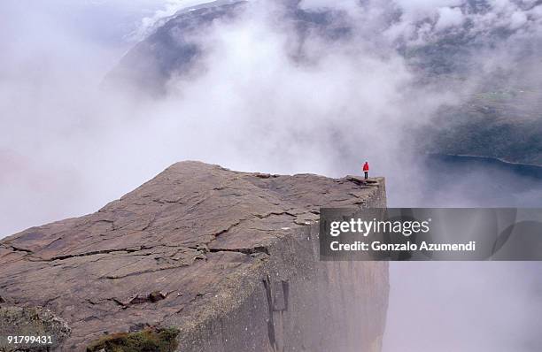 person standing on edge of cliff - preikestolen norway stock pictures, royalty-free photos & images