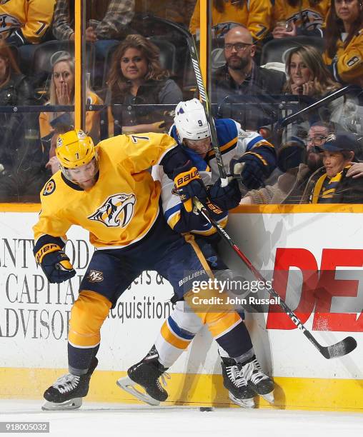 Yannick Weber of the Nashville Predators battles along the boards against Scottie Upshall of the St. Louis Blues during an NHL game at Bridgestone...