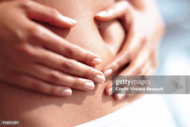 woman holding stomach - femme main ventre photos et images de collection