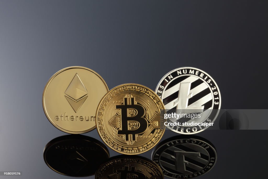 Cerrar tiro de tres cryptocurrencies principales; Bitcoin, Etereum y litecoin en la superficie oscura.