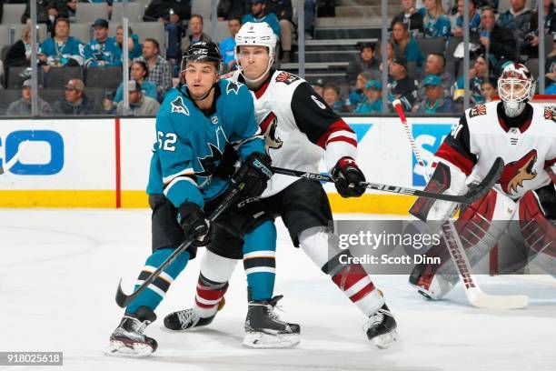 Jakob Chychrun of the Arizona Coyotes defends Kevin Labanc of the San Jose Sharks as Scott Wedgewood of the Arizona Coyotes protects the net at SAP...
