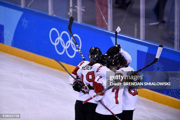 Switzerland's Christine Meier, Lara Stalder Switzerland's Alina Muller celebrate winning the women's preliminary round ice hockey match between...