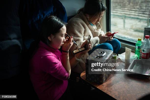 Woman puts on make up on the No. Z324 Lhasa-Chengdu train two days before the Chinese New Year holiday on February 13, 2018 in Xining, Qinghai...
