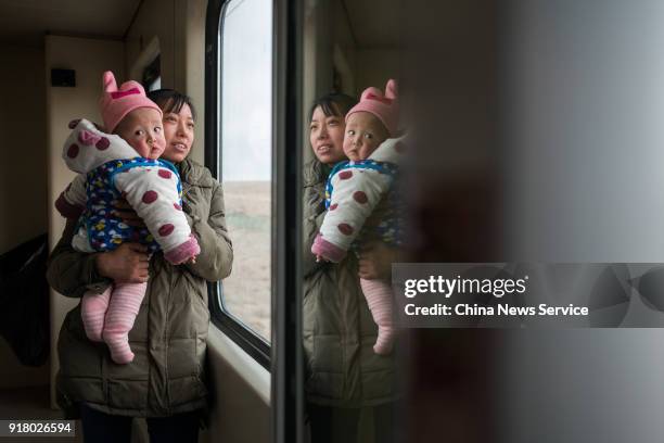 Mother and her daughter stand by a window on the No. Z324 Lhasa-Chengdu train two days before the Chinese New Year holiday on February 13, 2018 in...