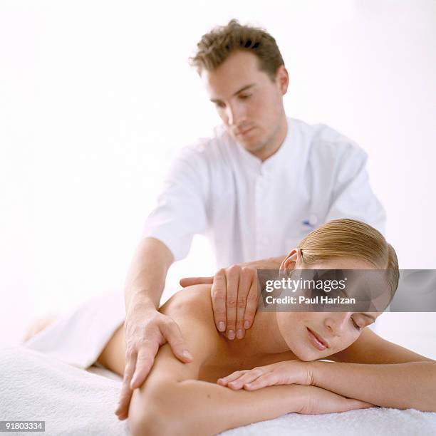 masseuse massaging a woman - girlfriend massage ストックフォトと画像