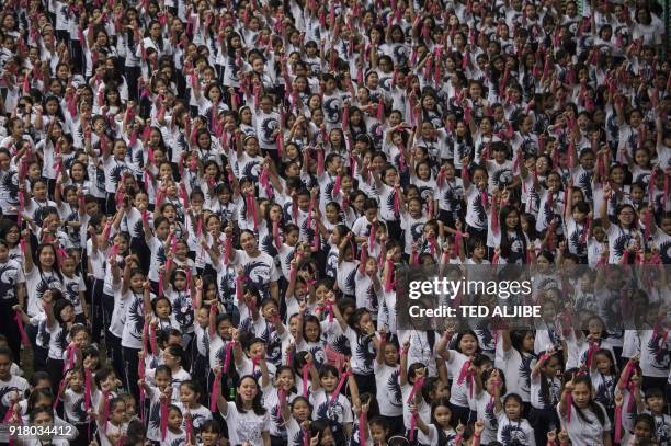Students of St. Scholastica's College gesture the "number one" sign as they dance to take part in the "One Billion Rising" global movement in Manila...