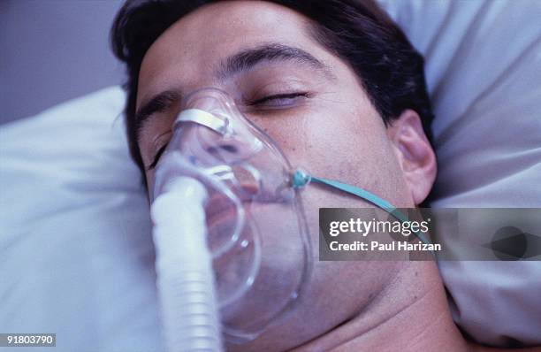 unconscious patient with oxygen mask - ventilator photos et images de collection