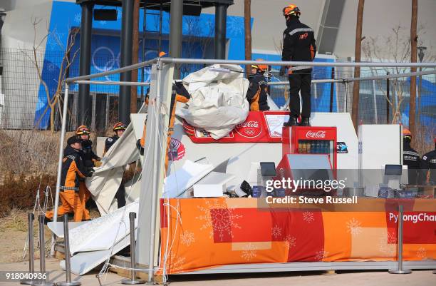 Pyeongchang- FEBRUARY 14 - Emergencey personnel dismantle a vendors stand that was shredded by winds. High winds forced the evacuation of the...