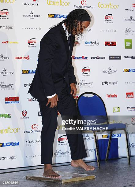 Brazilian AC Milan's football player Ronaldinho makes a foot print on October 12, 2009 in Monaco after he won the 2009 Golden Foot Award. The Golden...