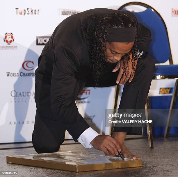 Brazilian AC Milan's football player Ronaldinho signs his foot print on October 12, 2009 in Monaco after he won the 2009 Golden Foot Award. The...