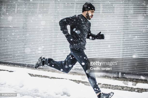 male athlete exercising outdoors in winter - jogging winter stock pictures, royalty-free photos & images