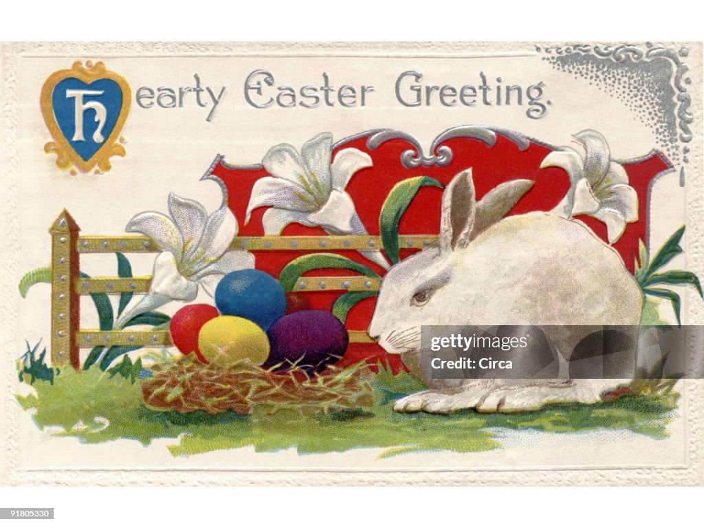 A vintage Easter postcard of lilies, a white rabbit and Easter eggs