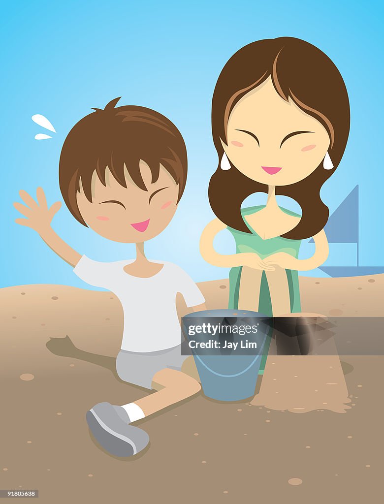 A mother and son building sand castles at the beach