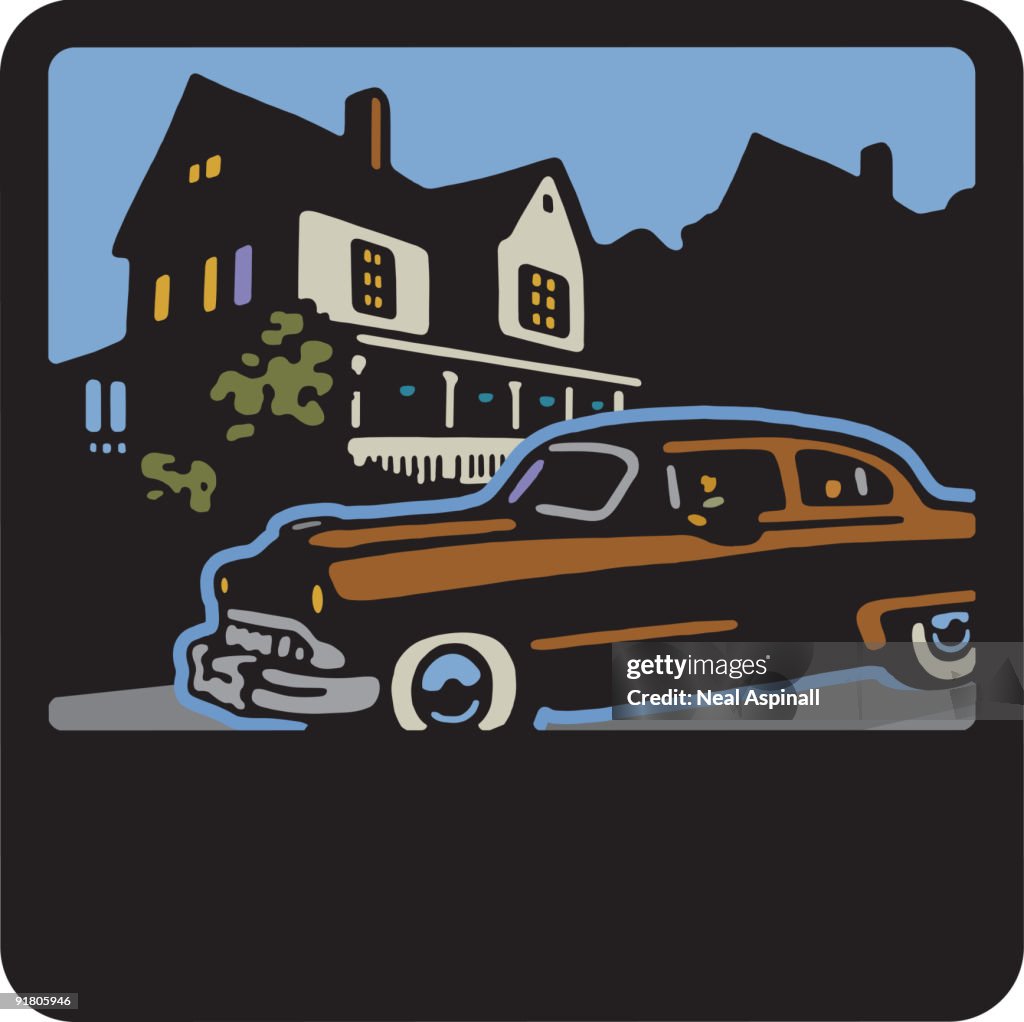A vintage car in front of a house