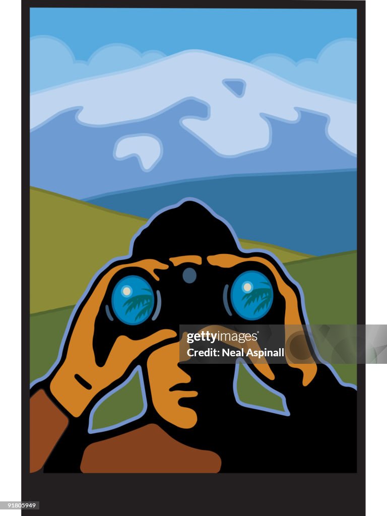 A man using binoculars looking out and mountains behind him