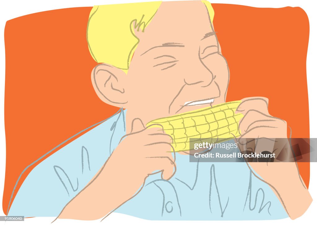A boy eating corn on the cob