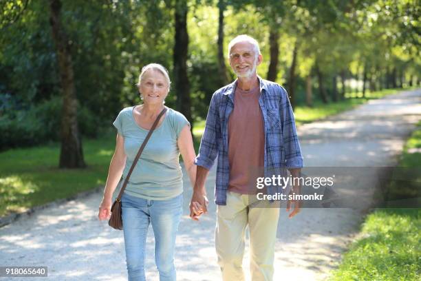 äldre par promenader tillsammans - öppna och stäng knapp bildbanksfoton och bilder