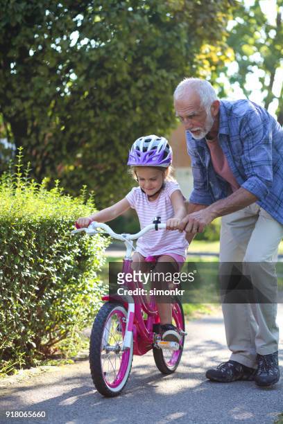 senior mannen att hjälpa barnbarn - öppna och stäng knapp bildbanksfoton och bilder