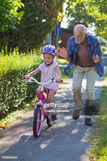 senior man helping granddaughter - open or close button stock pictures, royalty-free photos & images