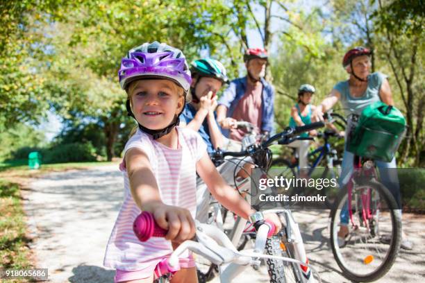 family riding bicycle in park - bicycle safety light stock pictures, royalty-free photos & images