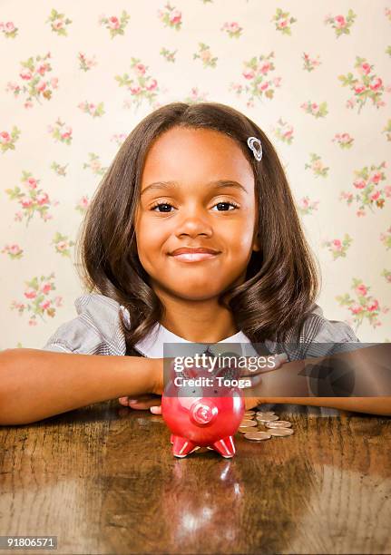 girl smiling with piggy bank - banbossy stock pictures, royalty-free photos & images