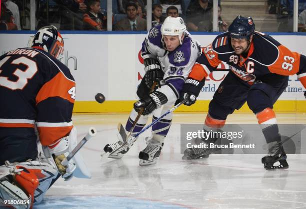 Ryan Smythe of the Los Angeles Kings is stopped by Martin Biron and Doug Weight of the New York Islanders at the Nassau Coliseum on October 12, 2009...