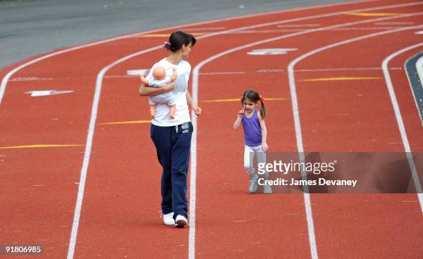 Katie Holmes and daughter Suri Cruise run track at a track field on October 12, 2009 in Boston, Massachusetts.