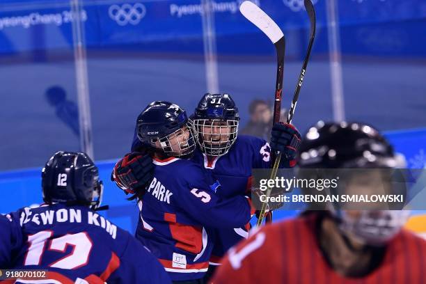 Unified Korea's Randi Griffin cheers with Caroline Nancy Park after scoring in the women's preliminary round ice hockey match between Japan and the...