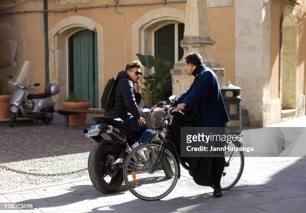 ortygia (syrakus), sizilien: zwei männer auf fahrrädern sprechen - ortygia stock-fotos und bilder