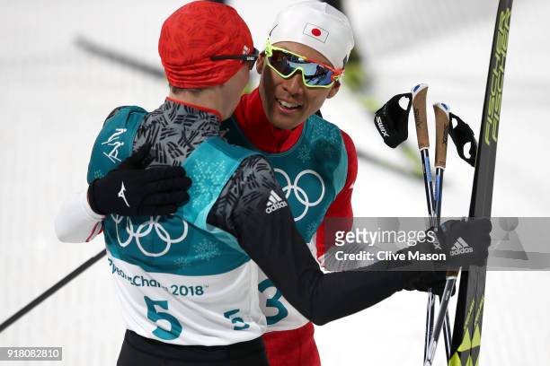 Gold medalist Eric Frenzel of Germany and silver Akito Watabe of Japan embrace after the Nordic Combined Individual Gundersen Normal Hill and 10km...