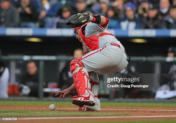 Carlos Ruiz of the Philadelphia Phillies fields a wild pitch in the bottom of the first inning against the Colorado Rockies in Game Four of the NLDS...