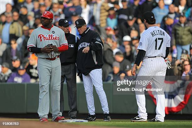 Manager Jim Tracy of the Colorado Rockies discusses a fielder's choice call with first base umpire Angel Hernandez as Ryan Howard of the Philadelphia...