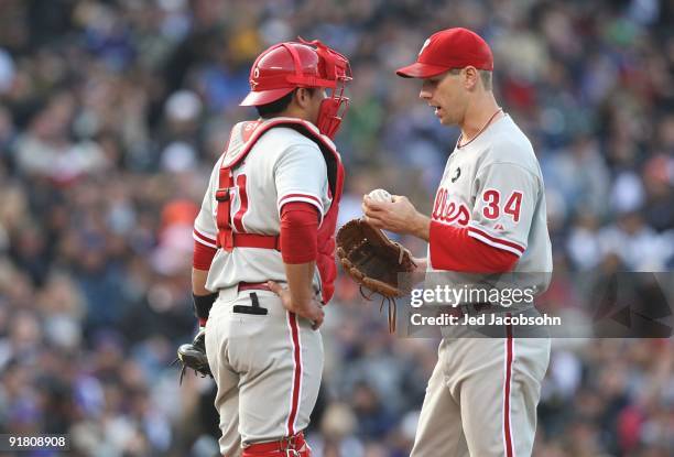 Cliff Lee of the Philadelphia Phillies talks to catcher Carlos Ruiz on the mound against the Colorado Rockies in Game Four of the NLDS during the...