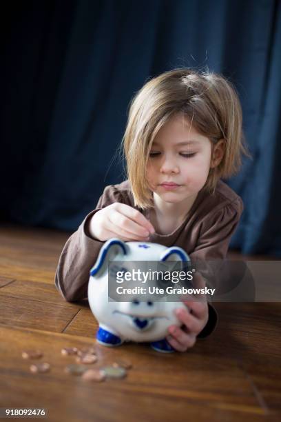 Bonn, Germany Five-year old girl poses with a piggy bank on February 03, 2018 in Bonn, Germany.