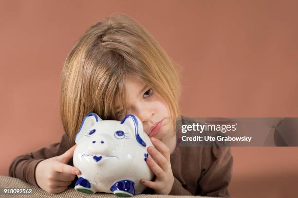 Bonn, Germany Five-year old girl poses with a piggy bank on February 03, 2018 in Bonn, Germany.