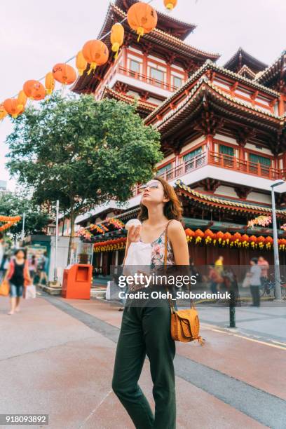 woman eating chinese bun    in chinatown in singapore - singapore food stock pictures, royalty-free photos & images