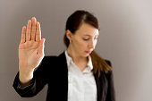 Woman in business suit showing her palm, body language, say NO at work, self-awareness