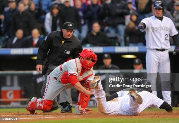 Todd Helton of the Colorado Rockies scores under the tag by Carlos Ruiz of the Philadelphia Phillies in the bottom of the sixth inning in Game Four...