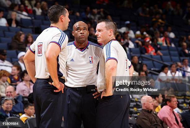 Official Brett Nansel, Tre Maddox and Kurt Walker huddle to discuss a call during a preseason game between the Golden State Warriors and the Los...