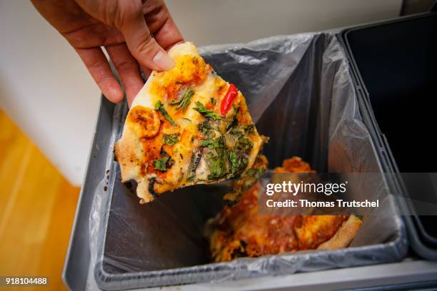 Berlin, Germany Symbolic photo on the topic food waste. A piece of pizza is thrown into a trash can on February 13, 2018 in Berlin, Germany.