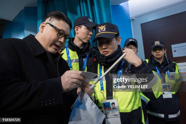 South Korean police check the ticket of a man impersonating North Korean leader Kim Jong Un after he was removed while appearing before North Korean...