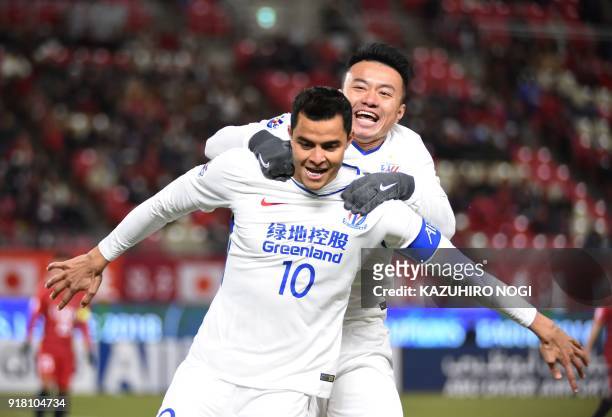 China's Shanghai Shenhua player Giovanni Moreno celebrates his goal with teammate Cao Yunding during their group stage football match against Japan's...