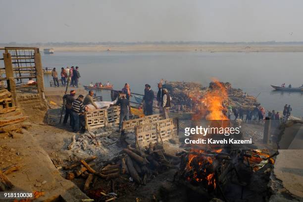 Body is laid on pyre while another burns during cremation in Manikarnika Ghat on January 28, 2018 in Varanasi, India. Manikarnika Ghat is one of the...