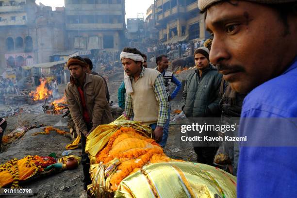 Relatives of a deceased man carry his body down the stairways of Manikarnika Ghat ready to be dipped into Ganga River for an act of purification...