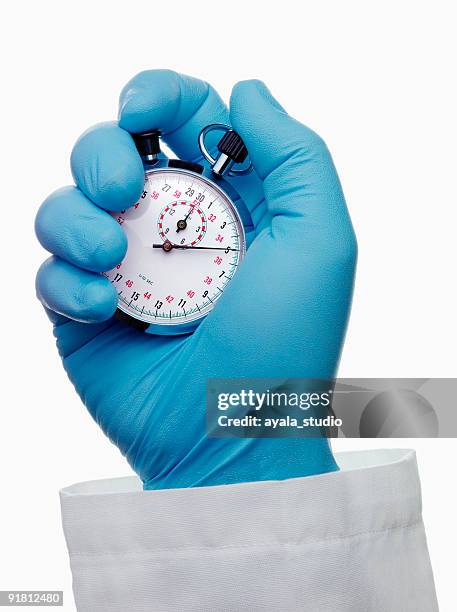 doctor holding chronometer - doctor gloves stock pictures, royalty-free photos & images